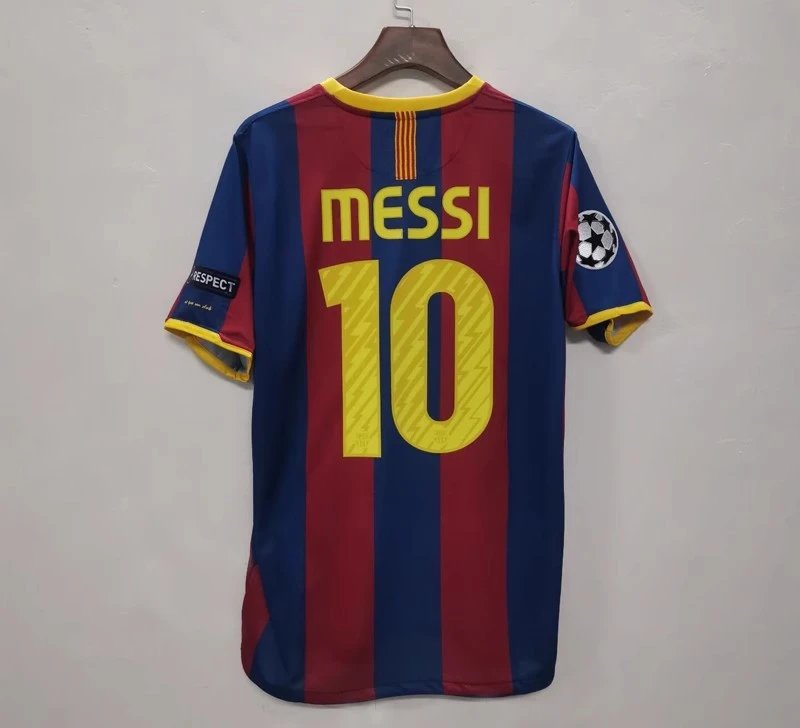 Barcelona football jersey with 'Messi 10' on a hanger against a gray background