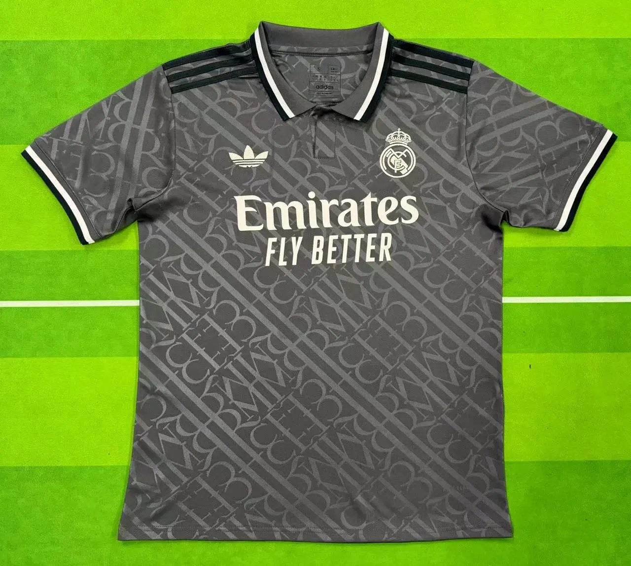 Gray sports jersey with Emirates and Adidas logos on a green background