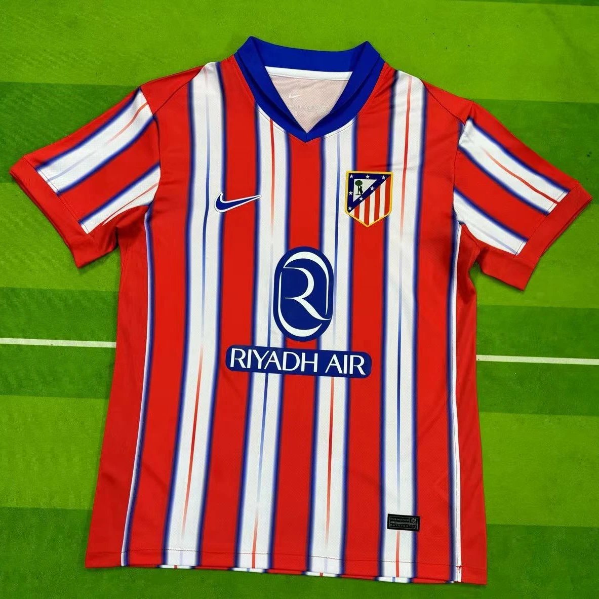 Red and white striped sports jersey with visible branding on a green field background