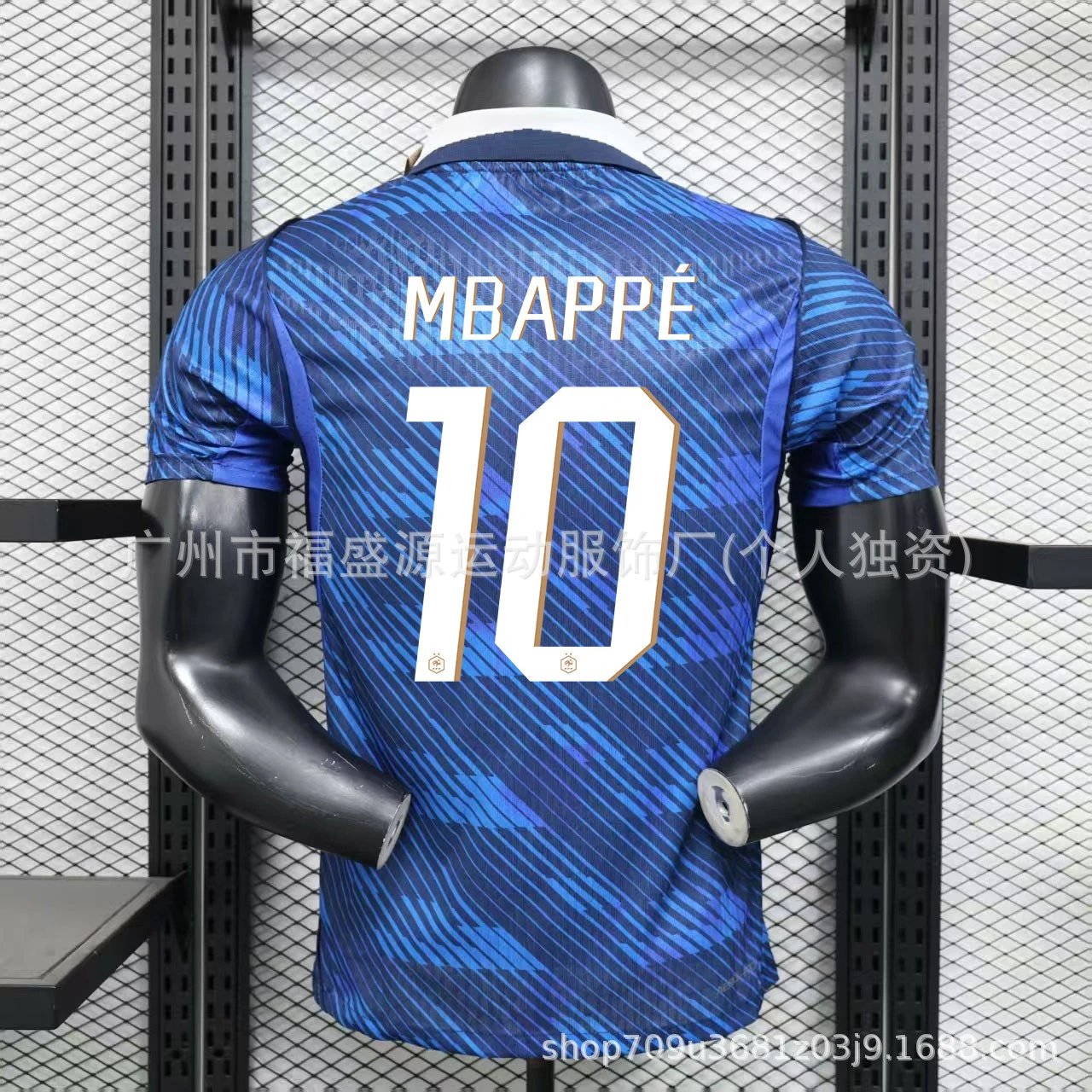 Blue sports jersey with 'MBAPPE' and number '10' on a mannequin against a wire mesh background.