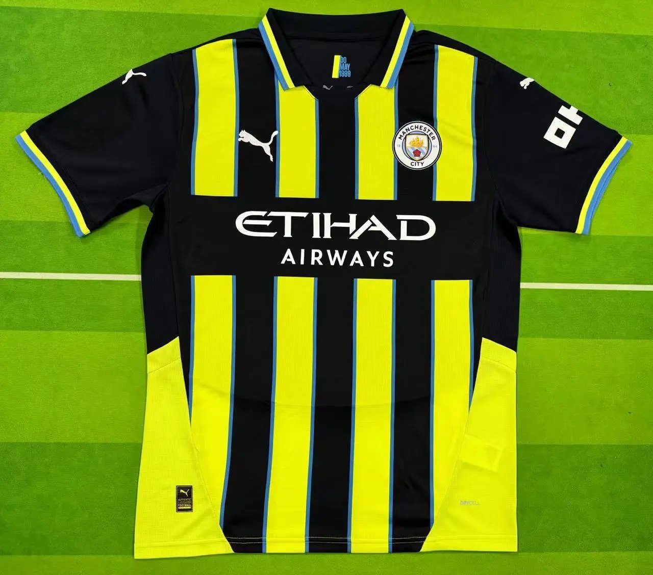 Black and yellow striped sports jersey with branding on a green background