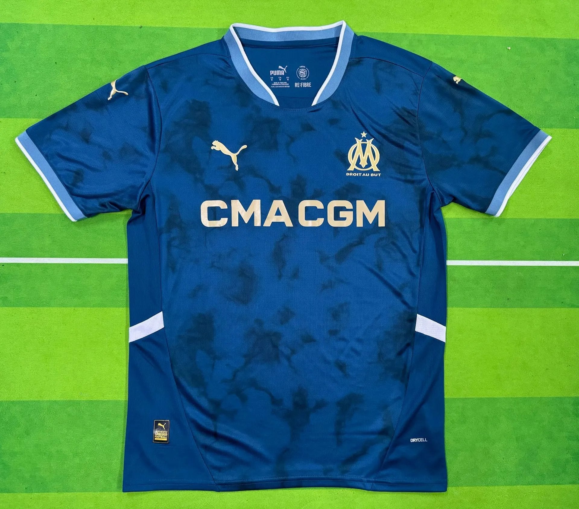 Blue sports jersey with visible branding on a green background