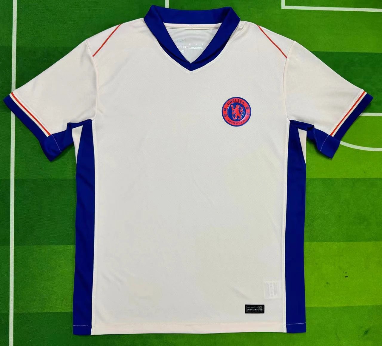 White soccer jersey with blue accents on a green field