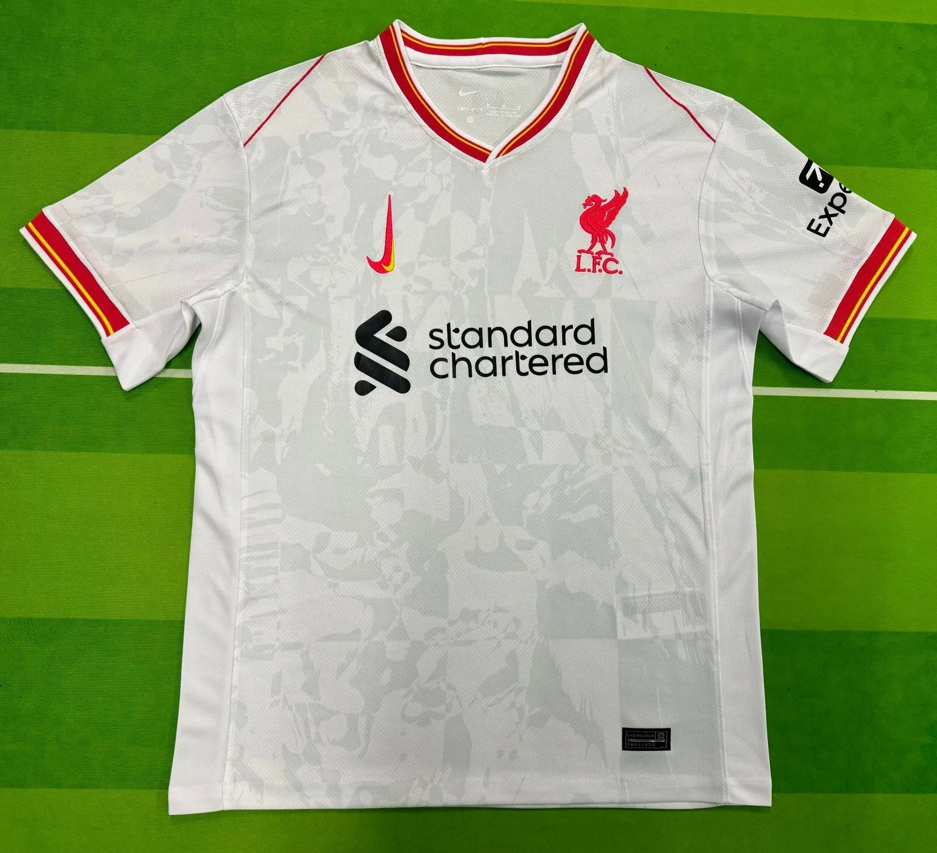 White sports jersey with red accents on a green background
