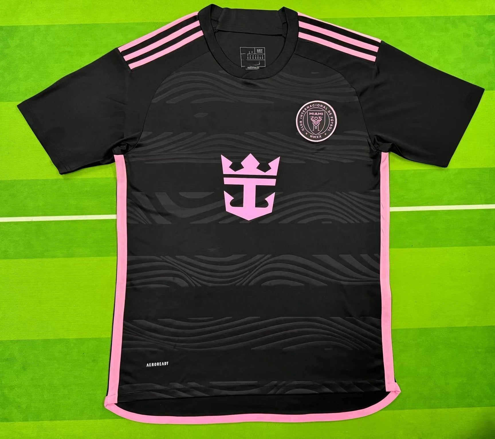 Black sports jersey with pink accents on a green background