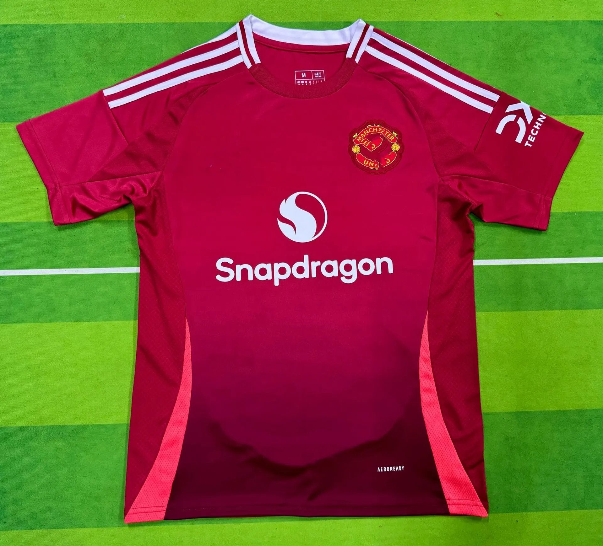 Red sports jersey with visible branding on a green background