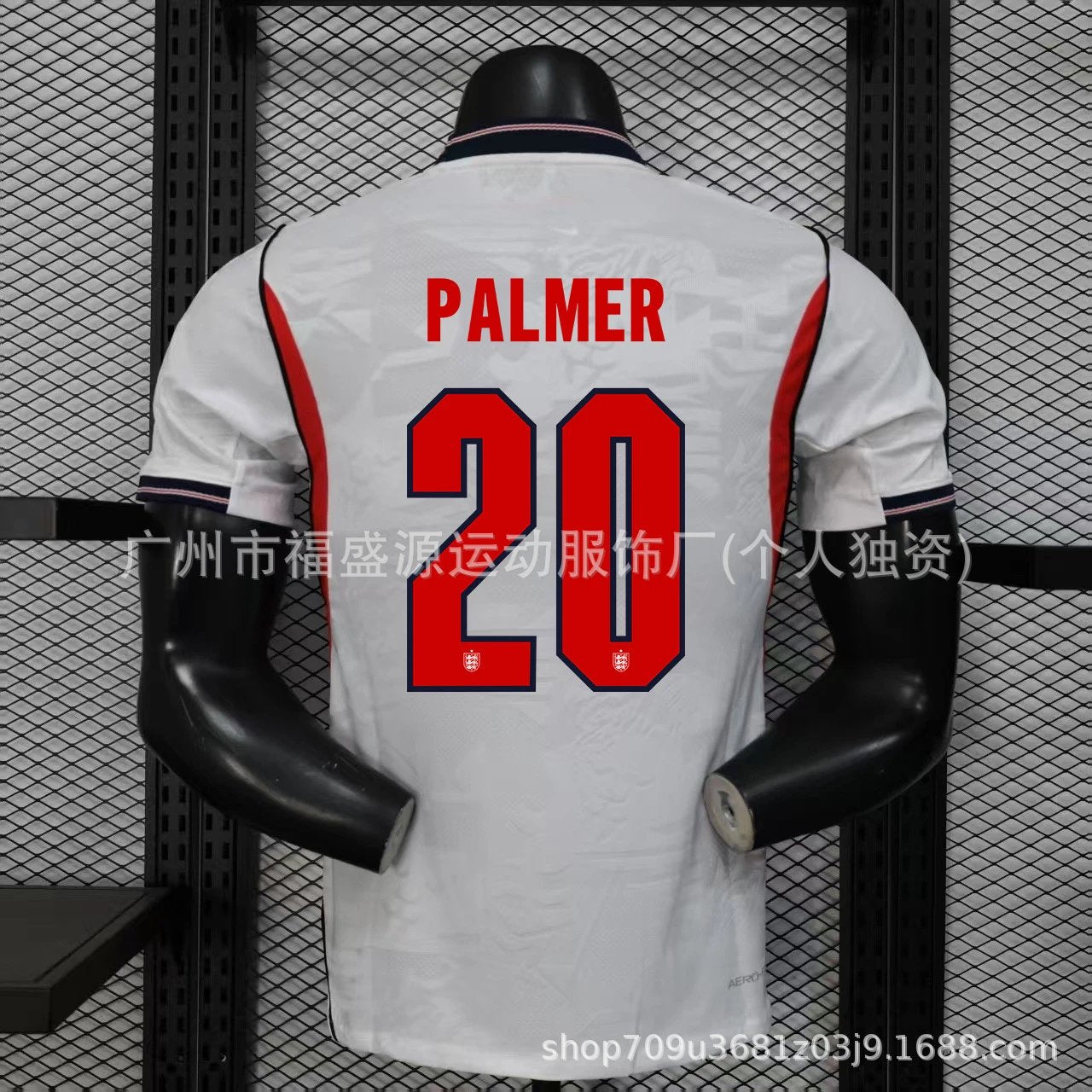 White sports jersey with red lettering and numbering on a mannequin against a black mesh background.