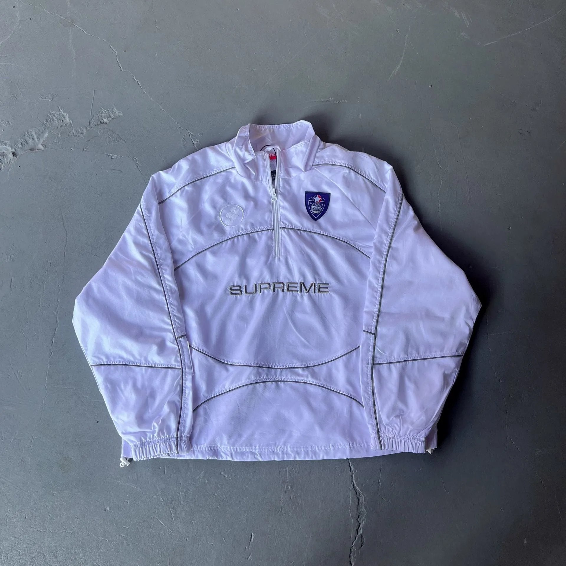 White jacket with a logo on a gray background
