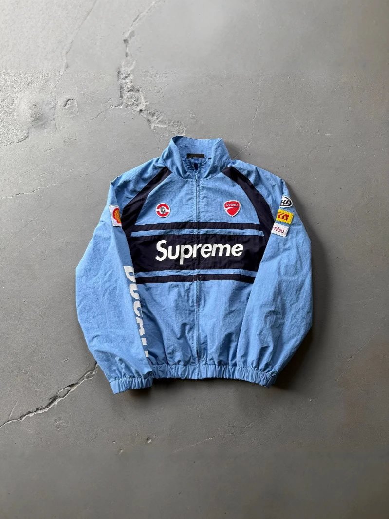 Blue jacket with Supreme logo on a gray surface