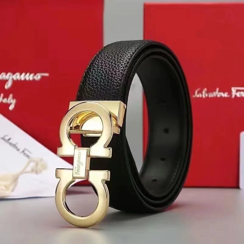 Black leather belt with gold buckle in front of a Salvatore Ferragamo box.