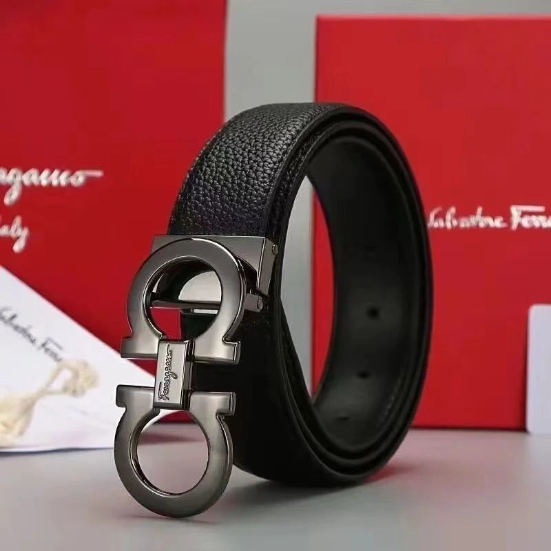 Black leather belt with silver buckle in front of a Salvatore Ferragamo box.
