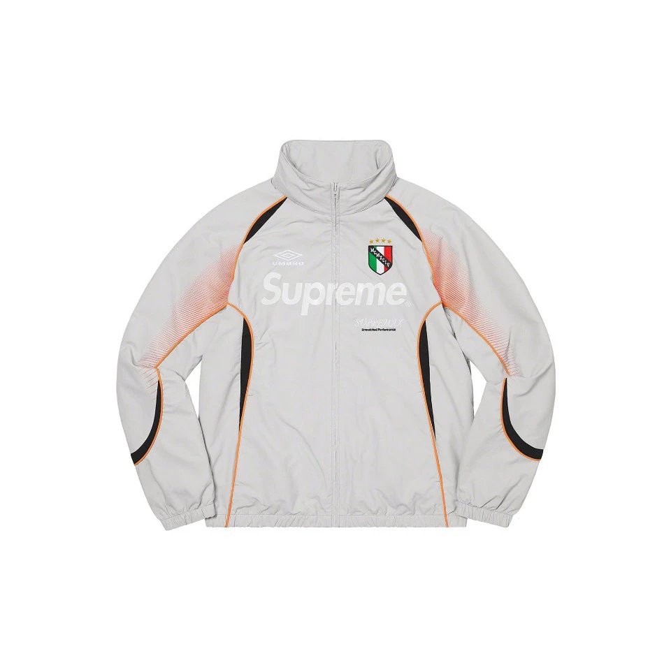 A light gray zip-up jacket featuring a prominent white 'Supreme' logo across the chest, an Italian flag crest, and orange and black accent lines on a white background.