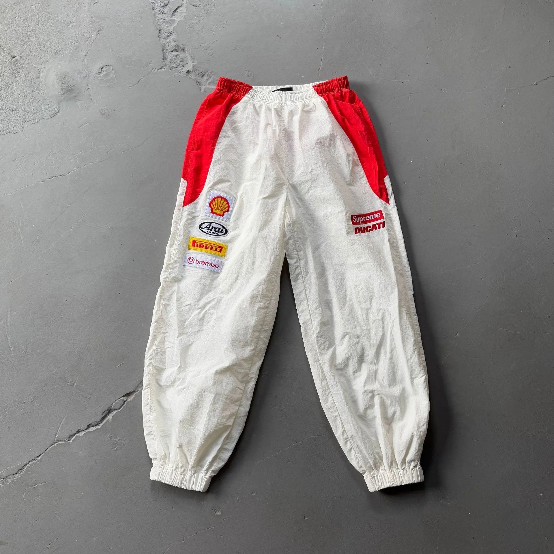 White pants with red accents on a gray surface