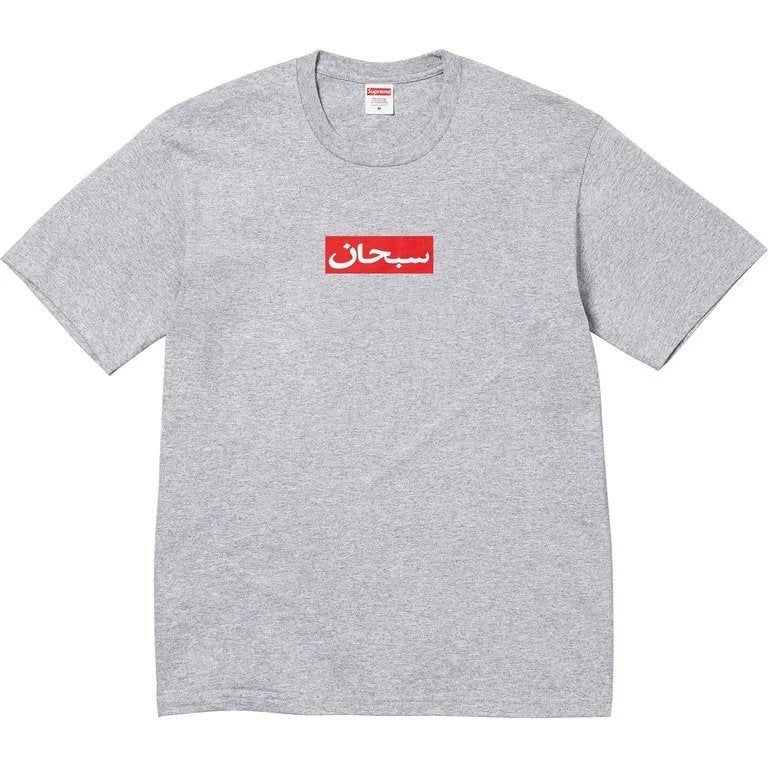A heather gray short-sleeve t-shirt with a red rectangular chest graphic containing white Arabic script, displayed flat against a white background.