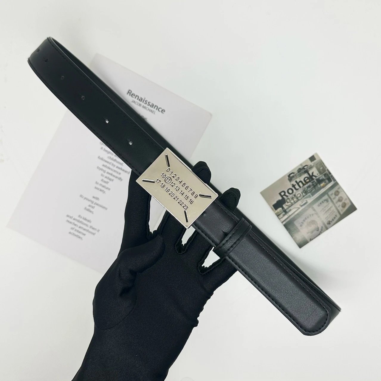 Hand holding a metal detector with a document and card on a white background