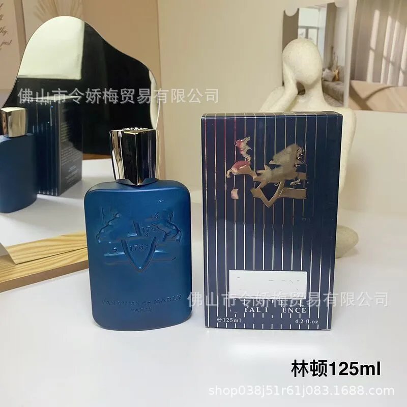 Blue perfume bottle and packaging on a white surface with a mirror in the background.