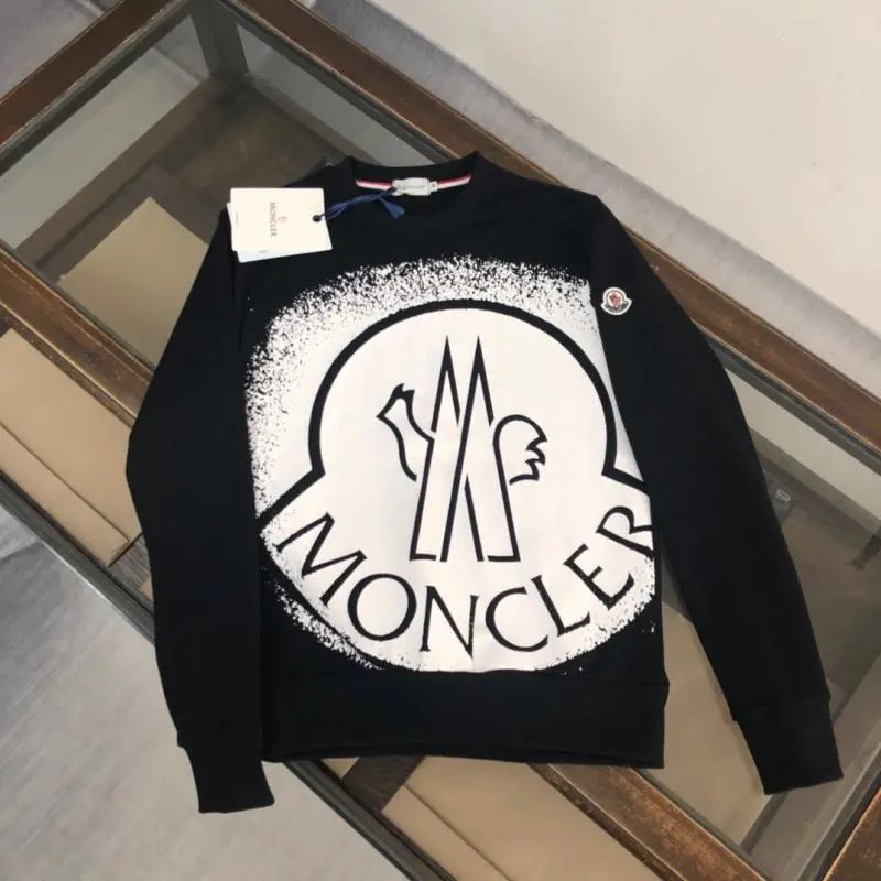 Black sweatshirt with a brand logo on a wooden surface