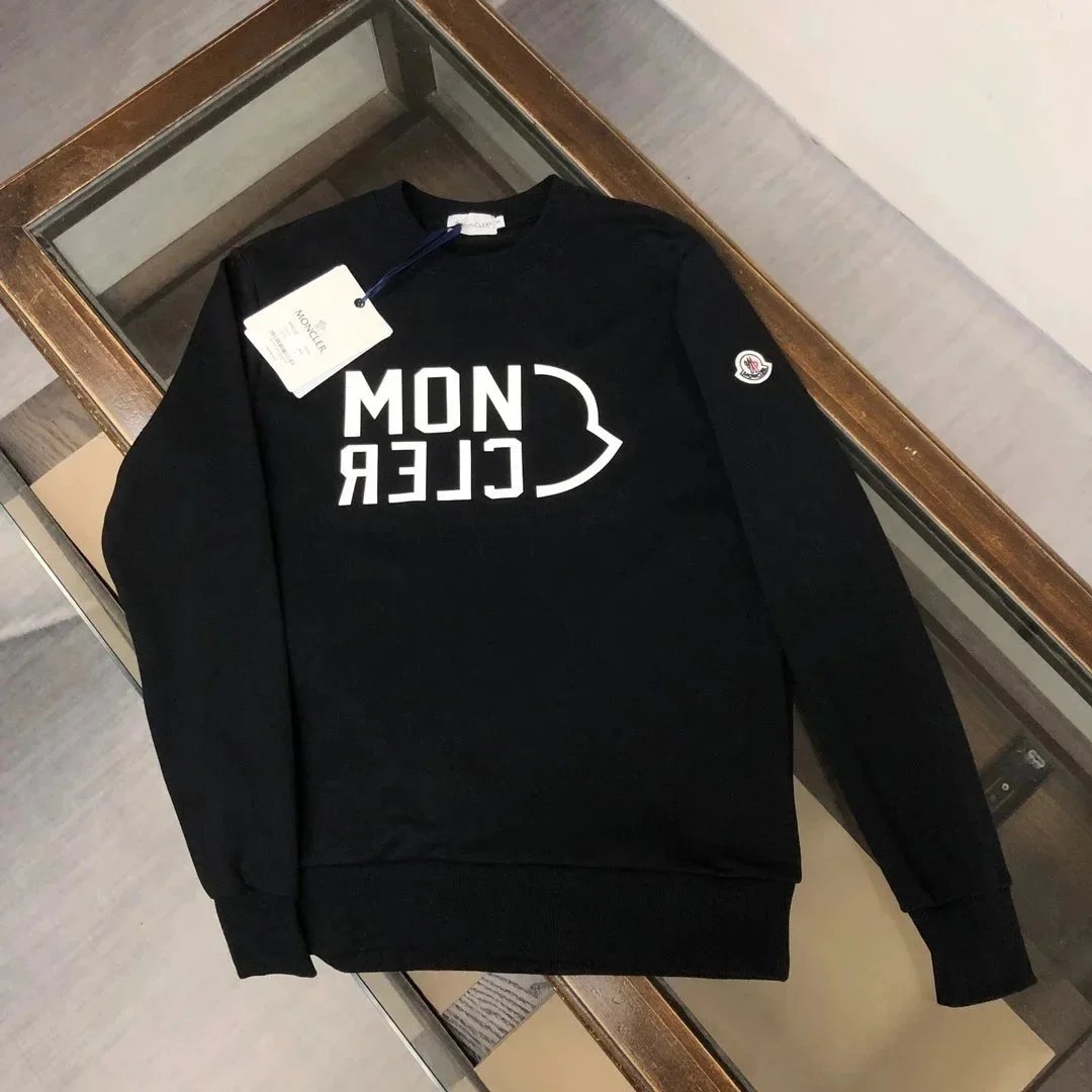 Black sweatshirt with white text on a wooden surface