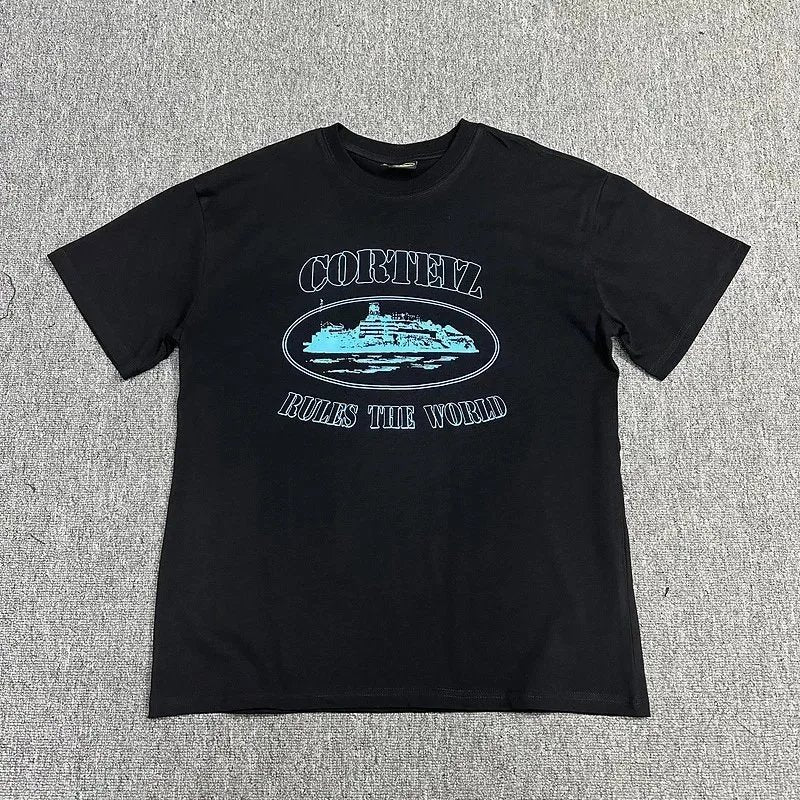 Black t-shirt with white and blue graphic design on a gray textured background