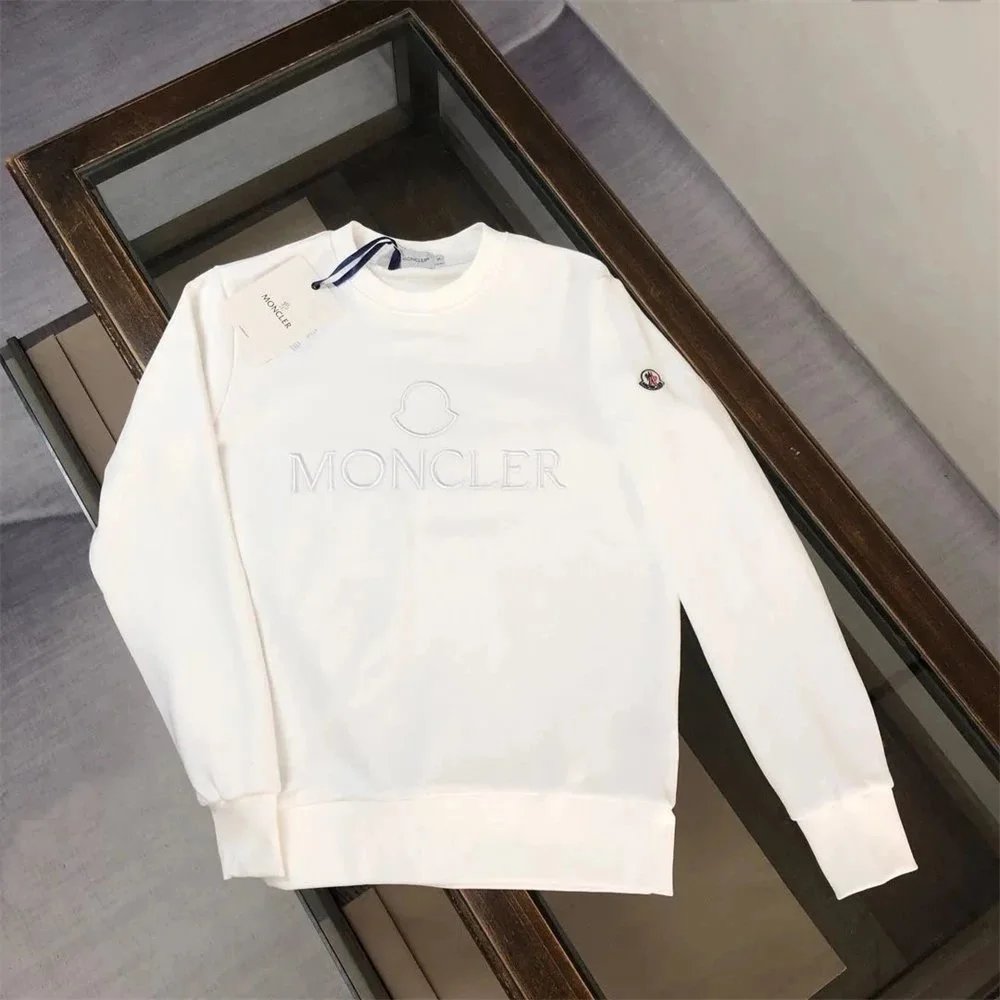 White sweatshirt with brand logo on a wooden surface