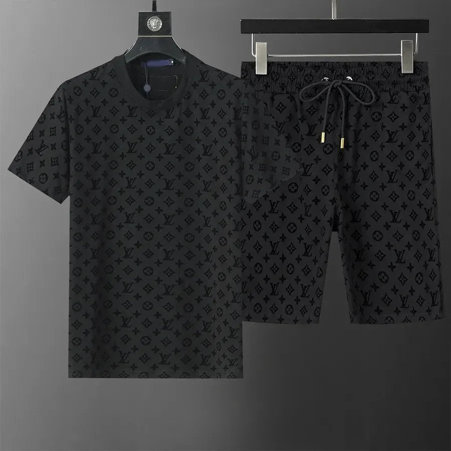 Black patterned t-shirt and shorts set on hangers against a gray background