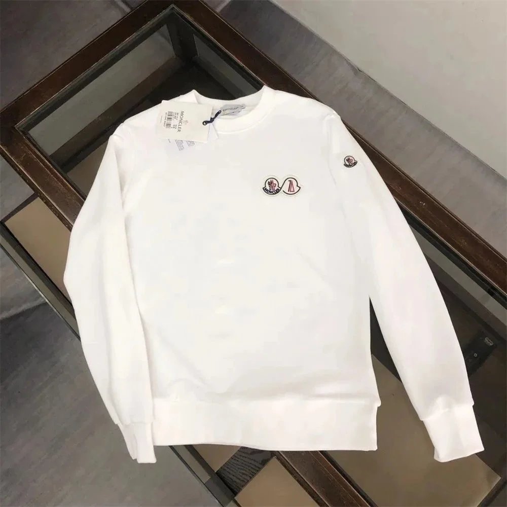 White sweatshirt with small decorative elements on a reflective surface