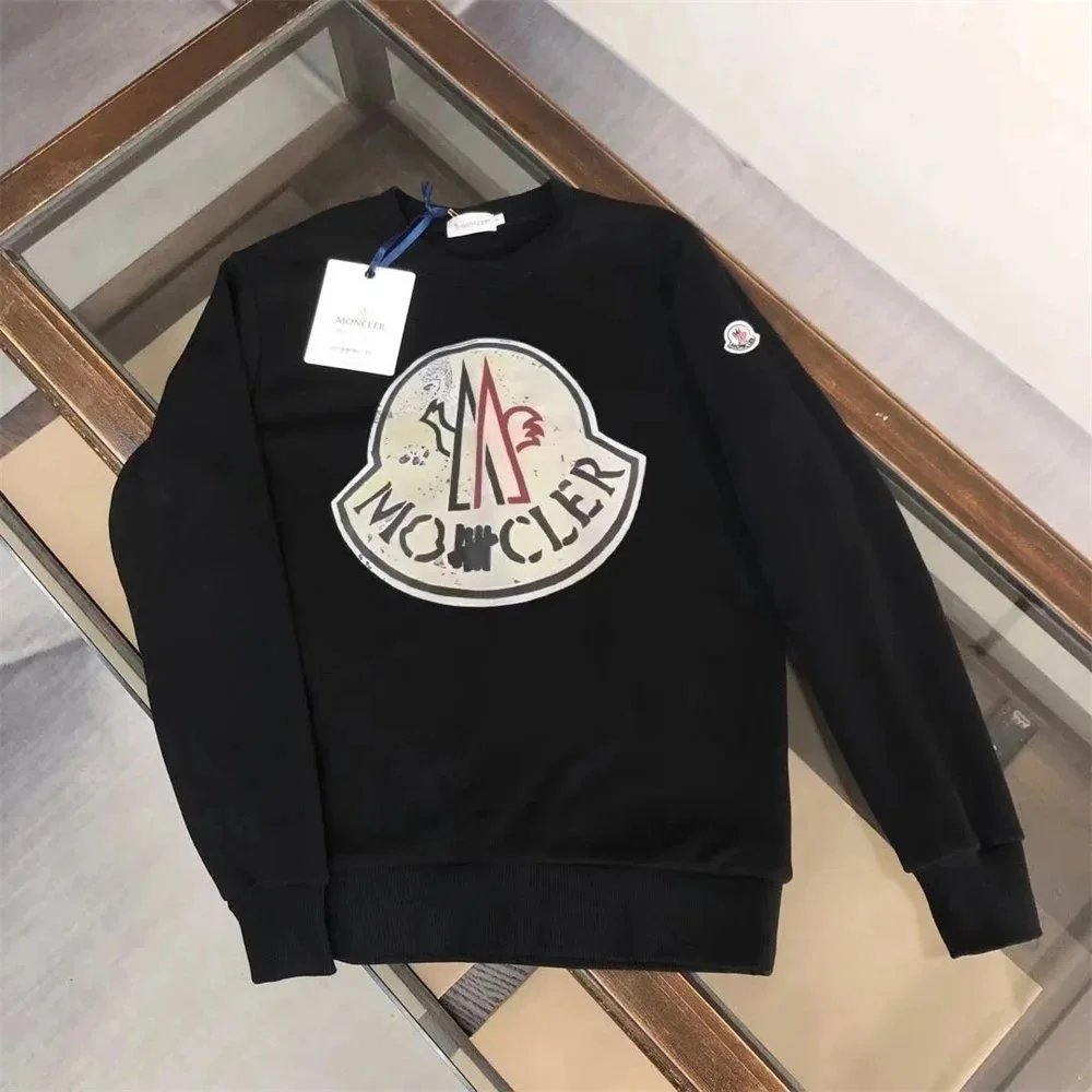 Black Moncler sweatshirt with logo on a glass surface