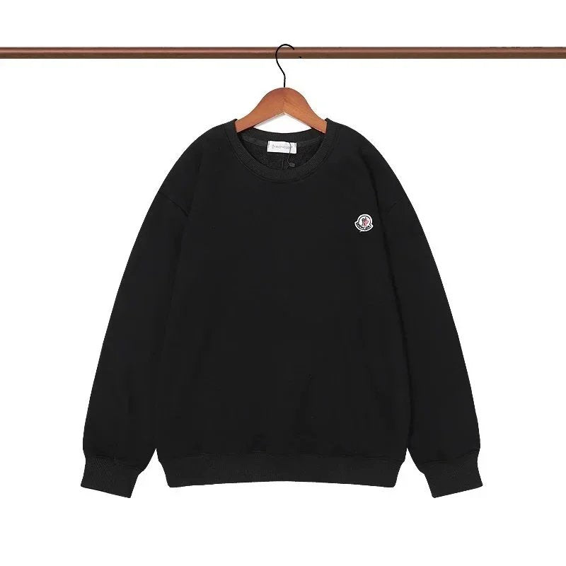 Black sweatshirt with a small logo on a hanger against a white background