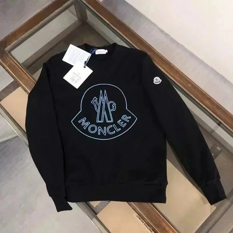 Black Moncler sweatshirt with a logo on a glass surface