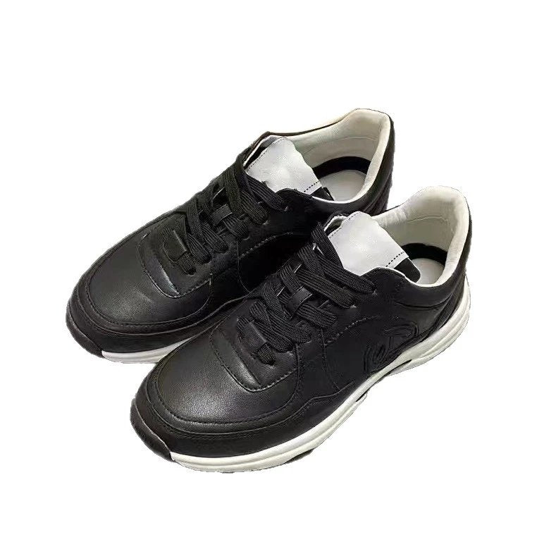 Pair of black sneakers with white soles on a white background