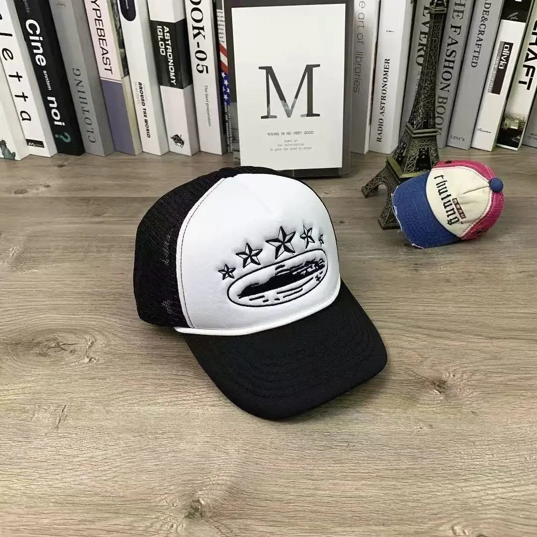 Black and white cap with star design on a wooden surface with books in the background