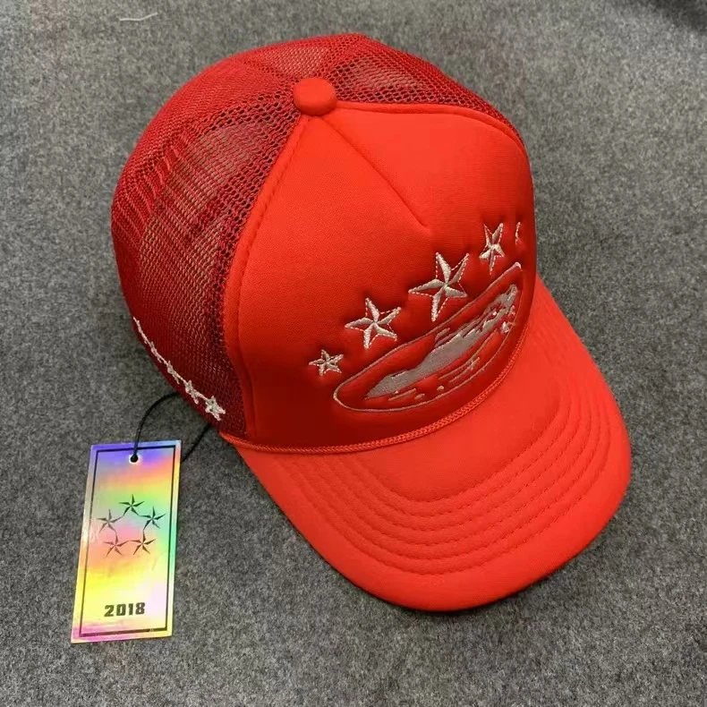 Red cap with embroidered design and tag on a gray background