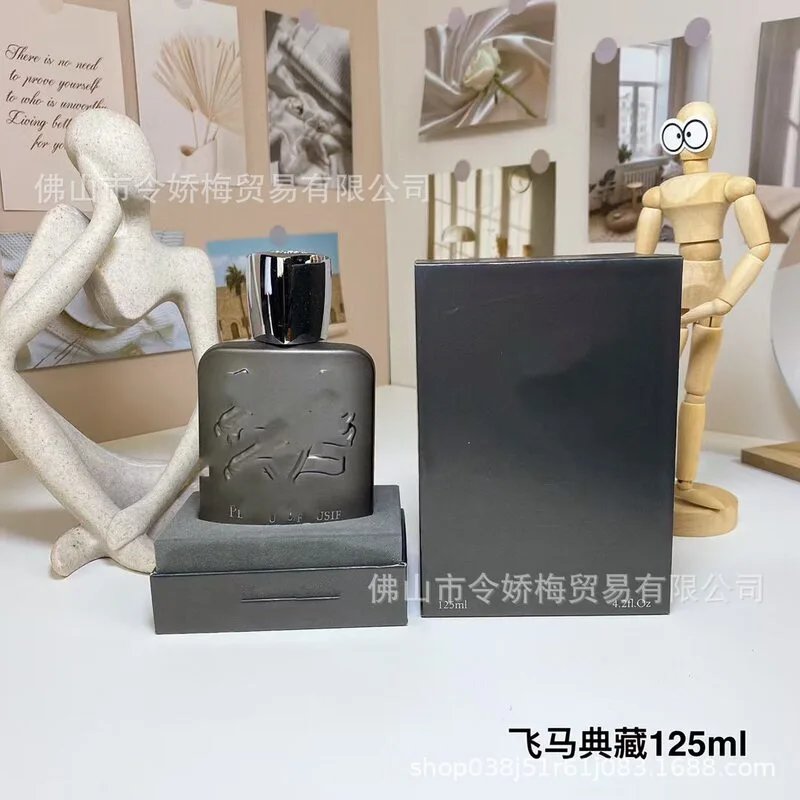 Black perfume bottle and packaging on a white surface with decorative elements in the background.
