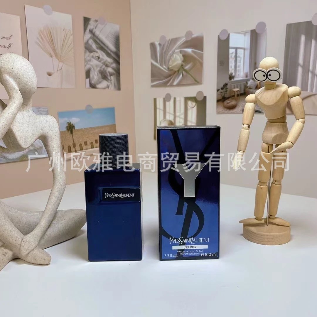 Two blue perfume bottles with their boxes on a white surface, surrounded by decorative items.