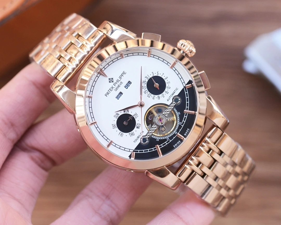 Gold wristwatch with detailed face held by a hand on a blurred background