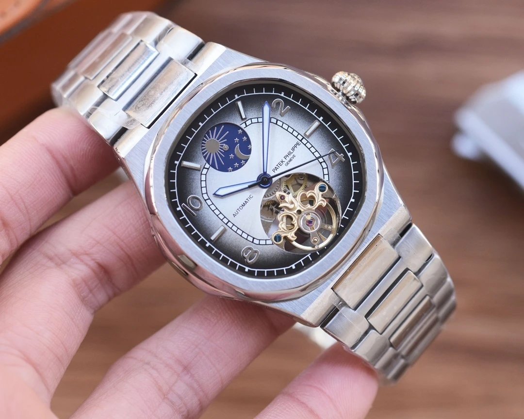 Silver wristwatch with detailed face held in a hand against a wooden background