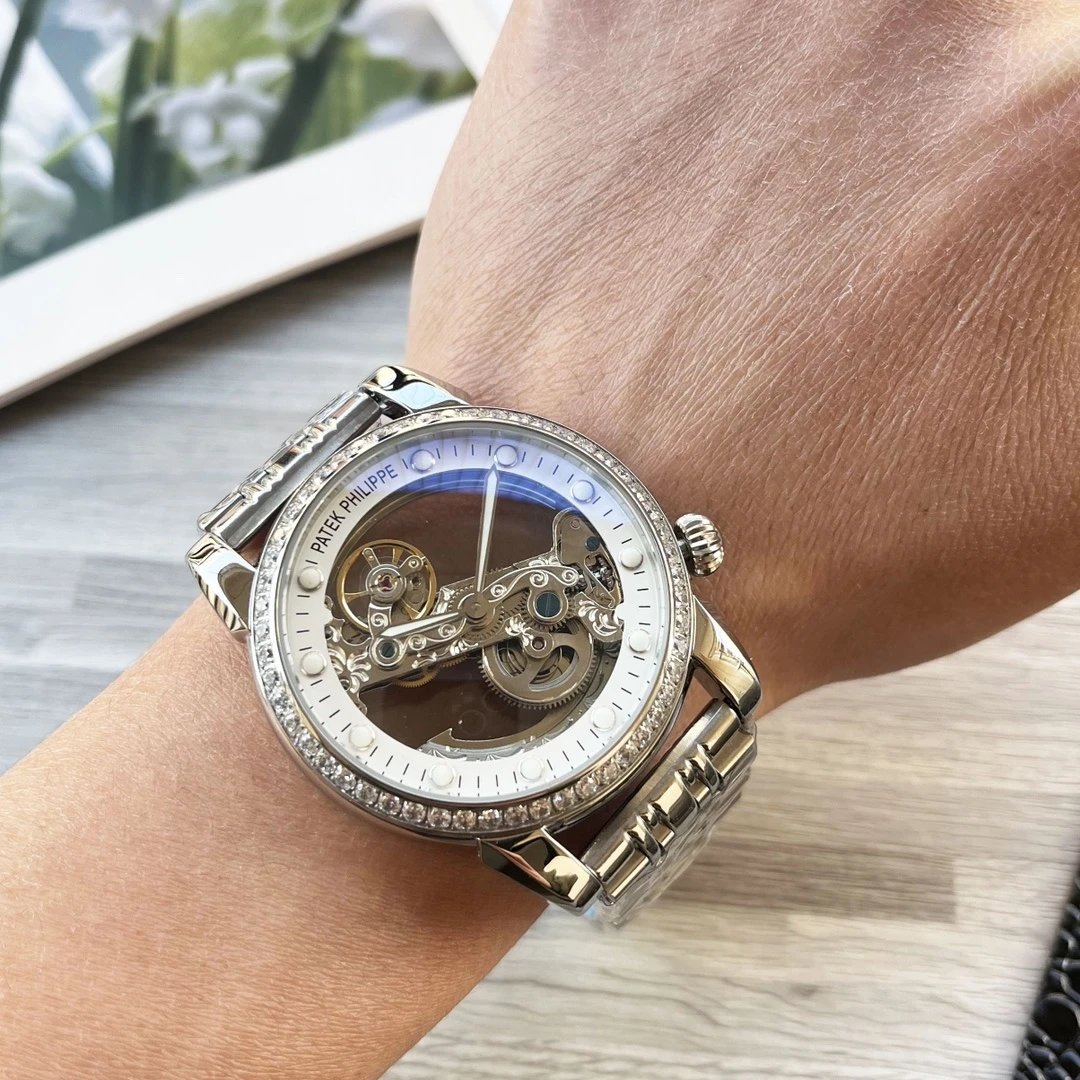 Luxury watch with visible brand name on a wrist against a blurred background
