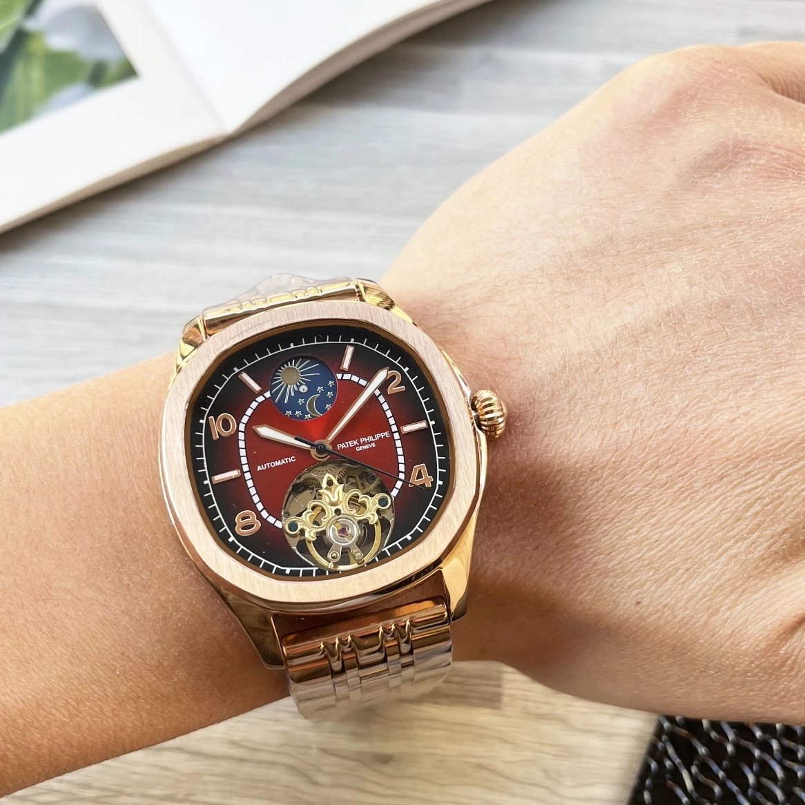 Rose gold wristwatch with a detailed face on a wrist, blurred background