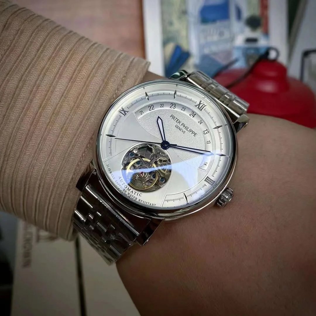 Silver watch with a white face on a wrist, blurred background