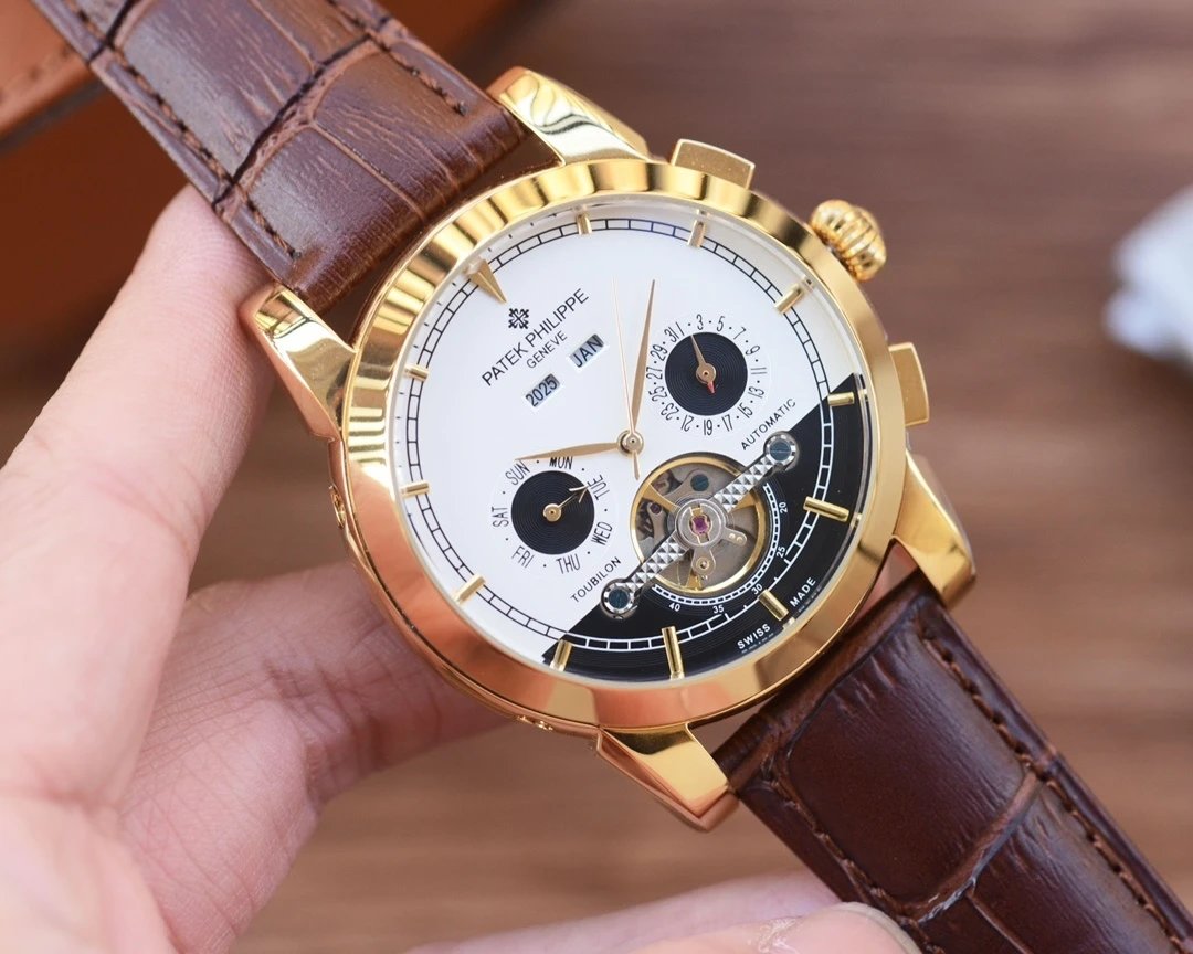 Gold wristwatch with a brown leather strap held by a hand on a blurred background