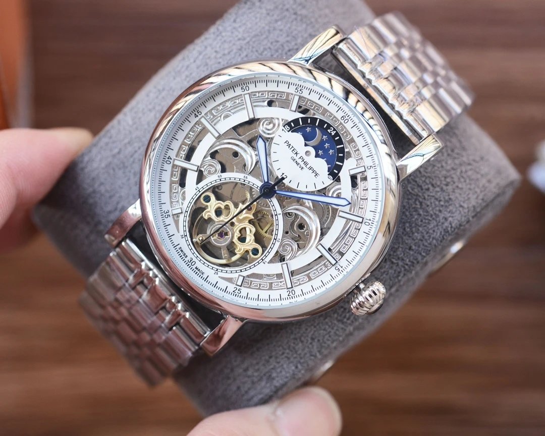 Luxury watch with intricate design held by a hand on a blurred background