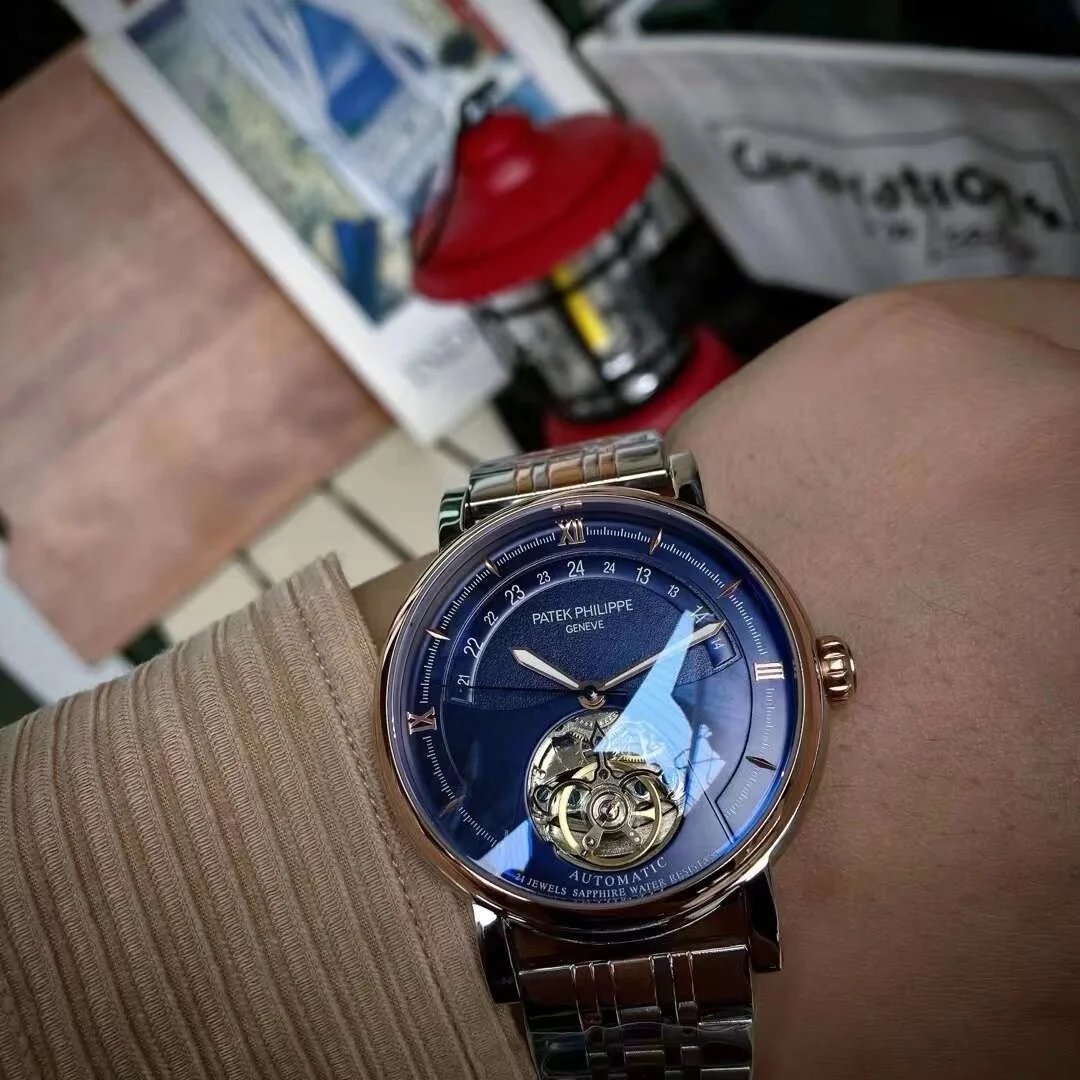 Close-up of a wrist wearing a Patek Philippe watch with a blue face.