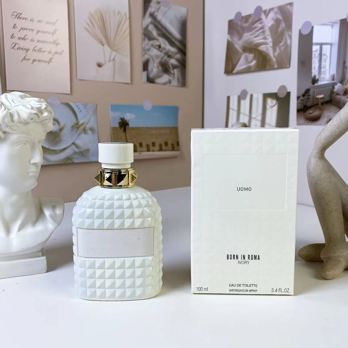 White textured perfume bottle with packaging on a surface, surrounded by decorative items.