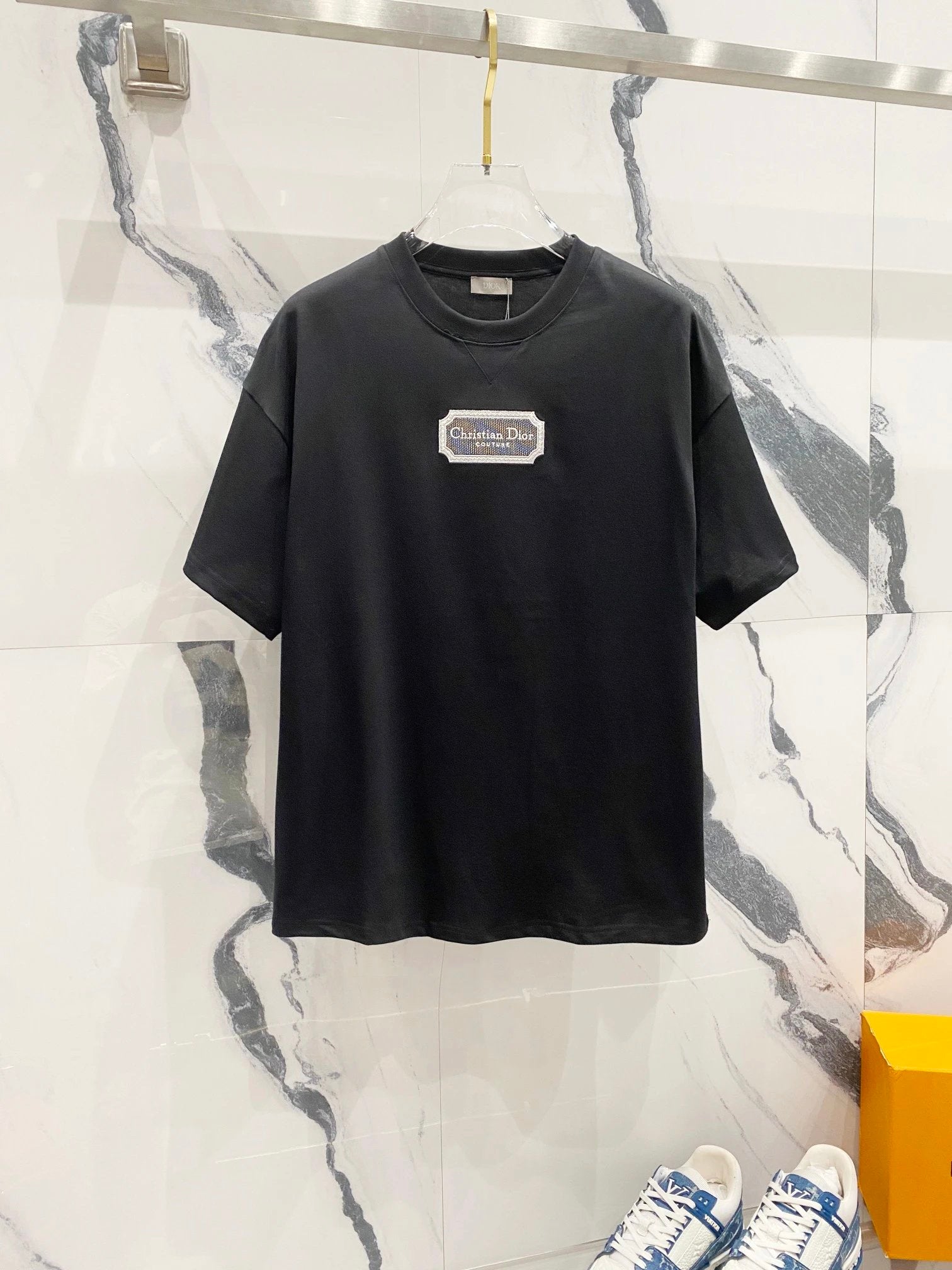 Black t-shirt with a logo on a marble background