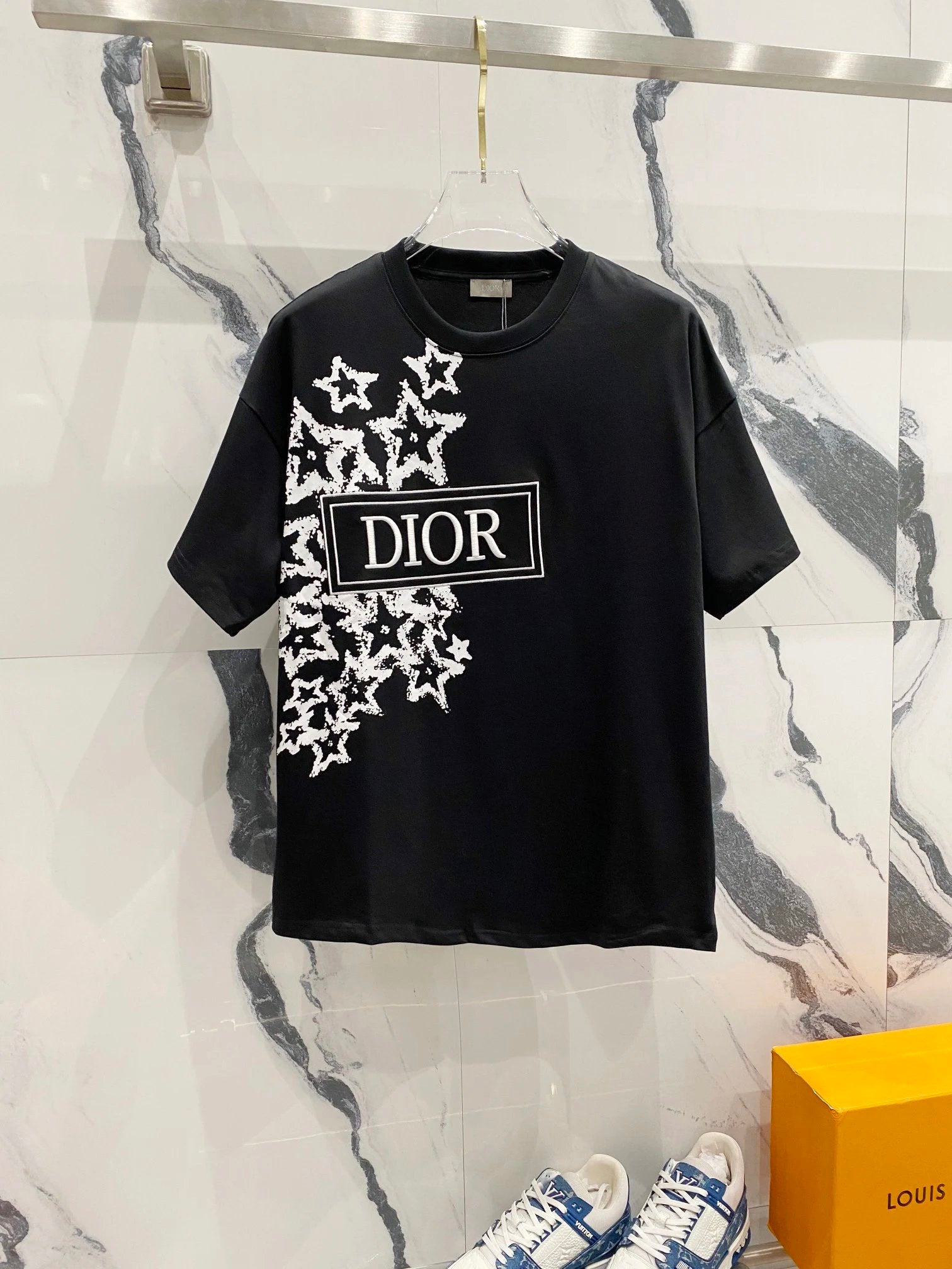 Black t-shirt with Dior logo and design on a marble surface
