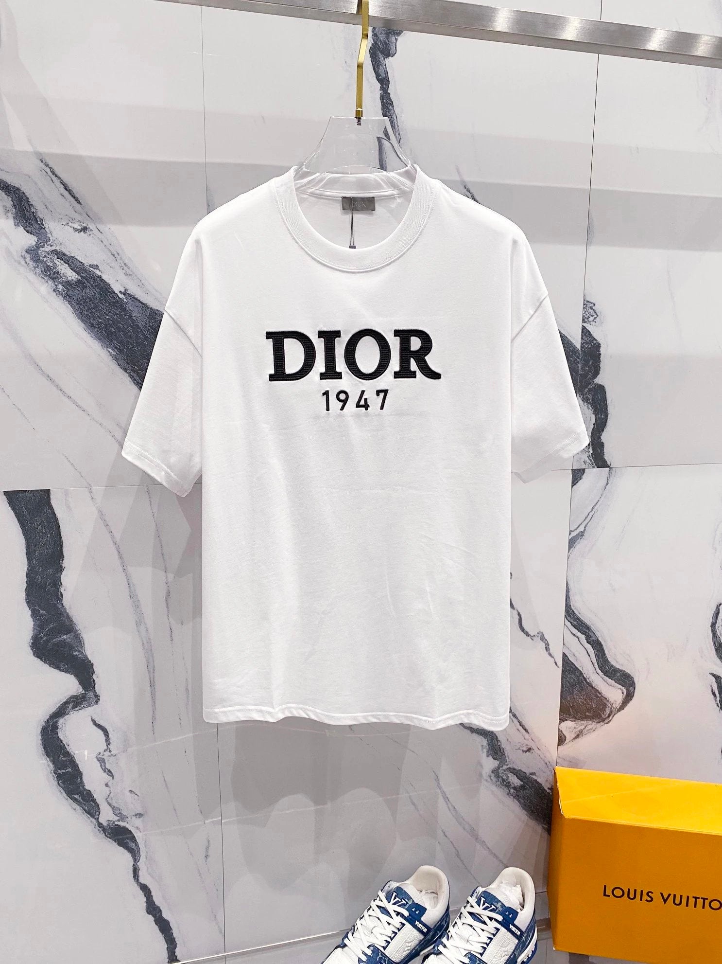 White t-shirt with 'Dior 1947' text on a marble background