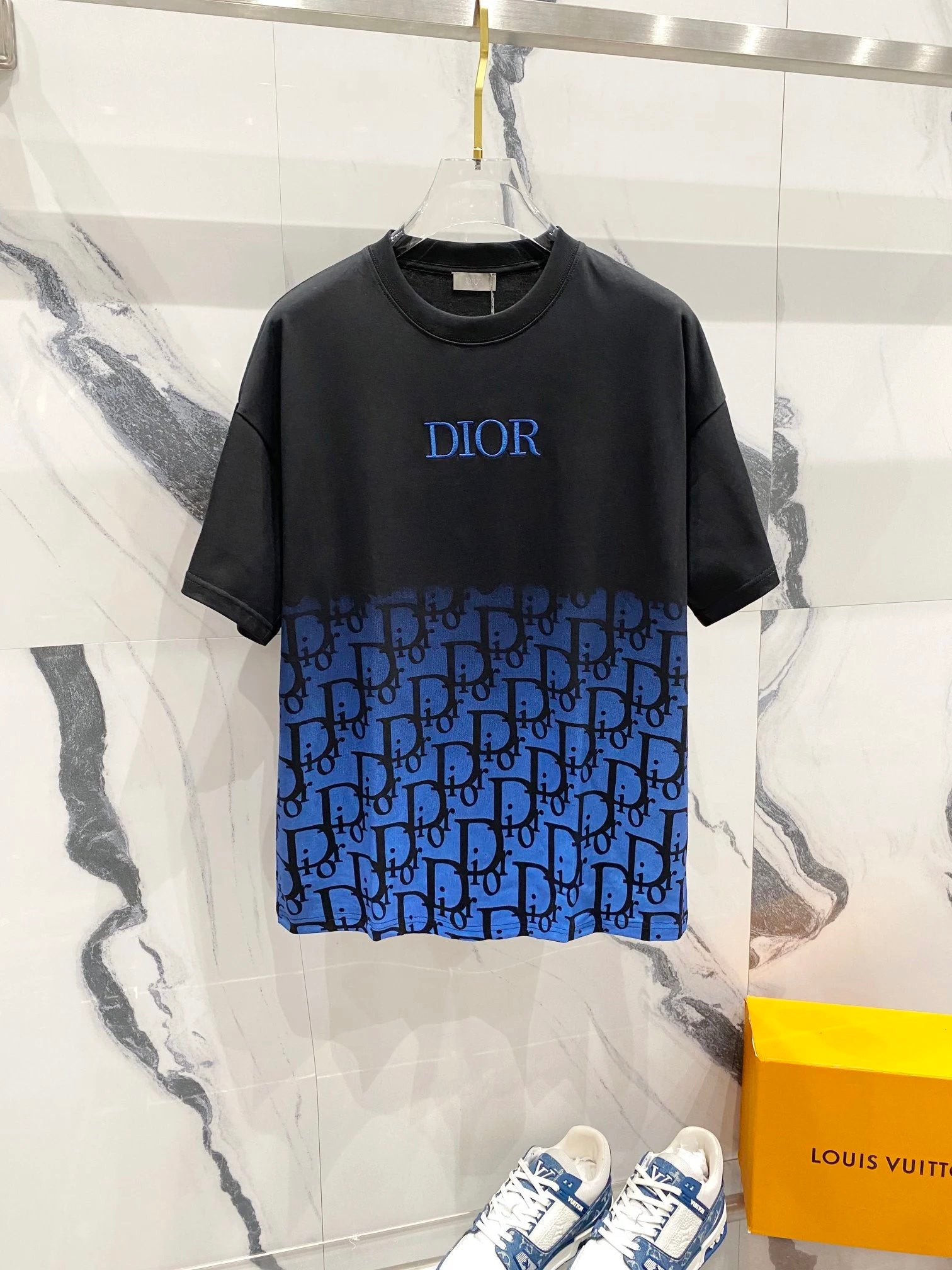 Black and blue gradient t-shirt with 'Dior' branding on a marble surface.