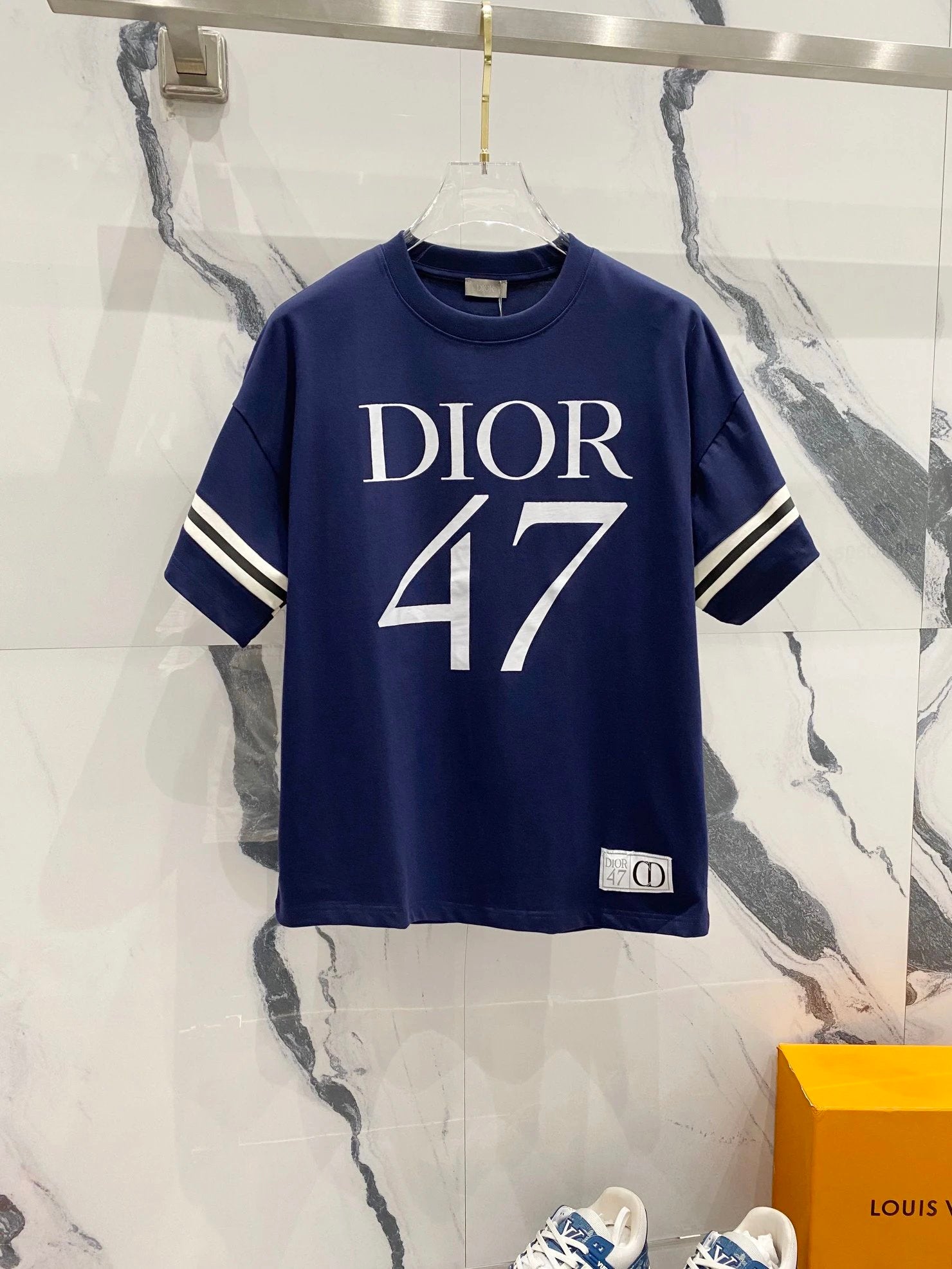 Navy blue t-shirt with 'Dior 47' print on a marble background