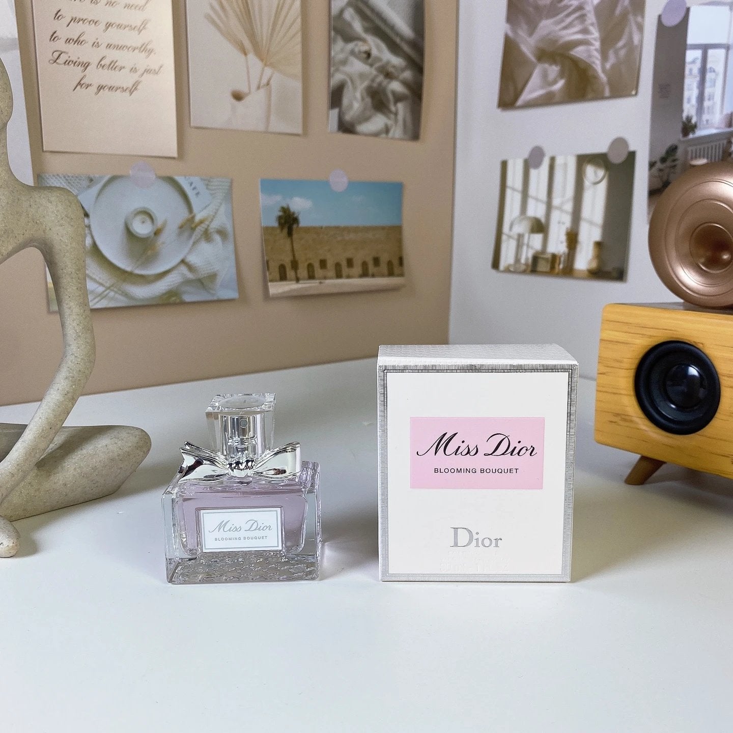 Dior Miss Dior Blooming Bouquet perfume bottle and packaging on a table with decorative items.