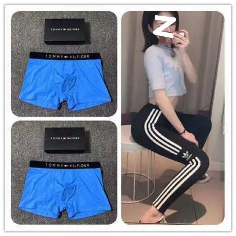 Blue Tommy Hilfiger boxer briefs with packaging and a person wearing black pants with white stripes.